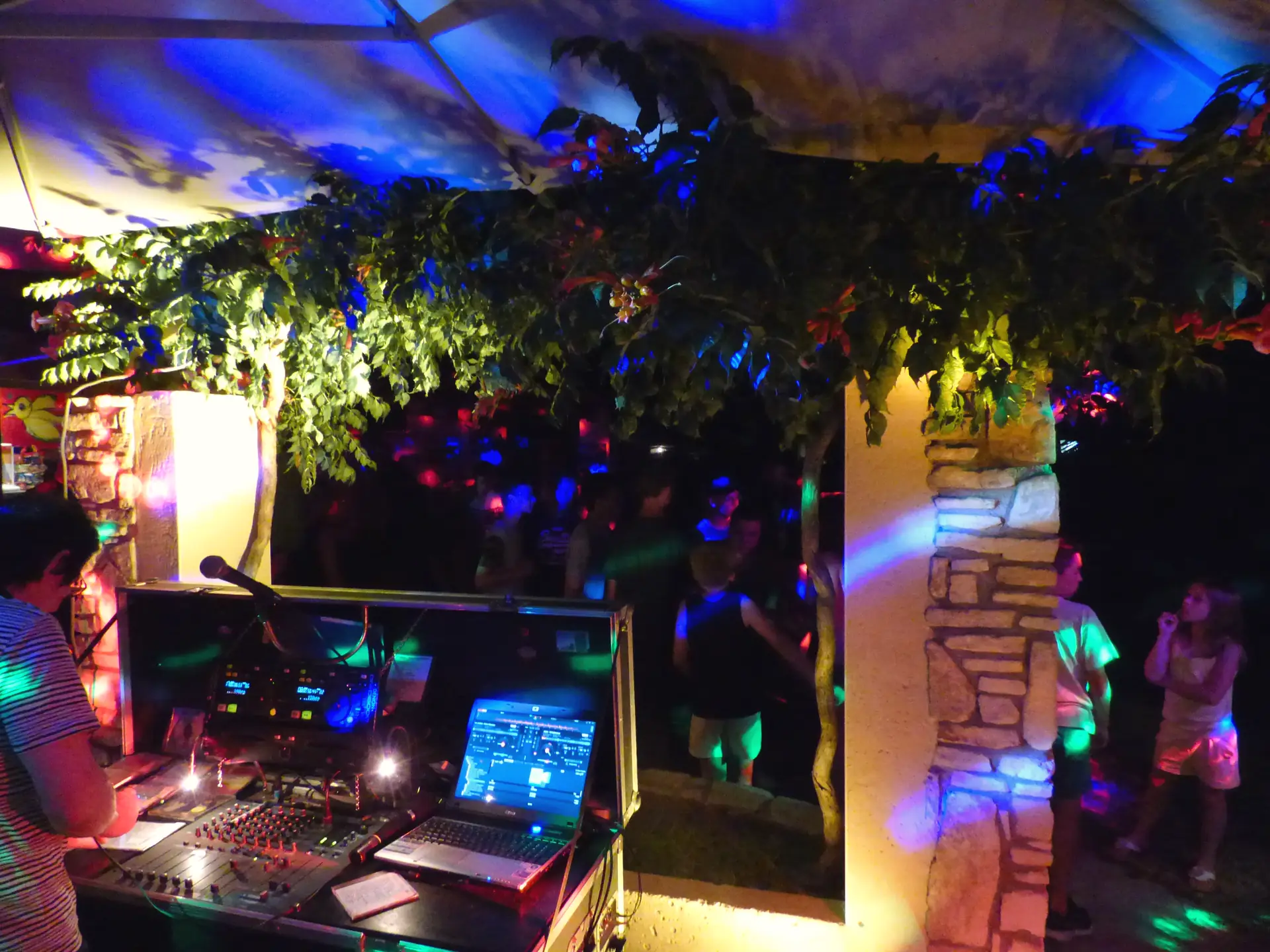 Table de mixage sous la tonnelle illuminée, un soir de fête au camping