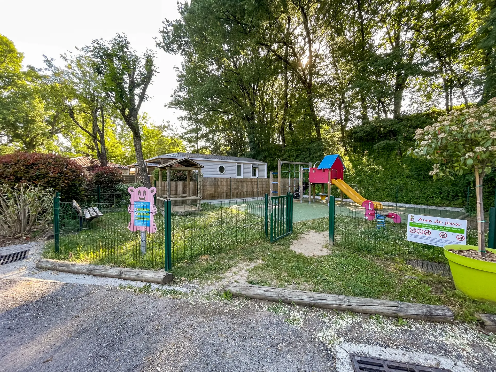 The fenced entrance to the playground, its gate and its sign