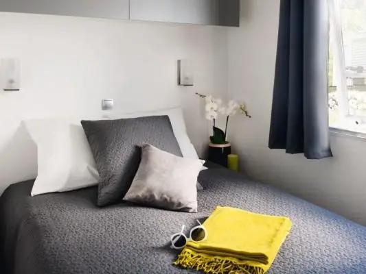 The mobile home bedroom with a double bed and cushions