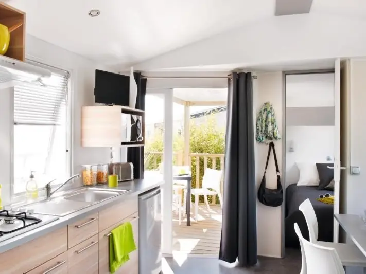 The equipped kitchen and dining area of the mobile home, opening onto the terrace