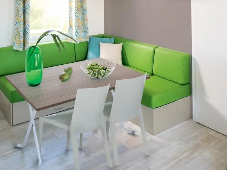 Coin repas du mobil-home avec banquette, table et chaises