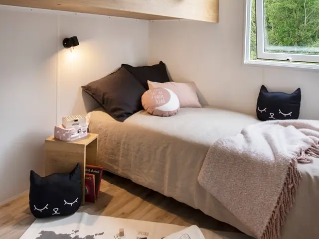 Ein Schlafzimmer des Mobilheims mit Einzelbett und Kissen