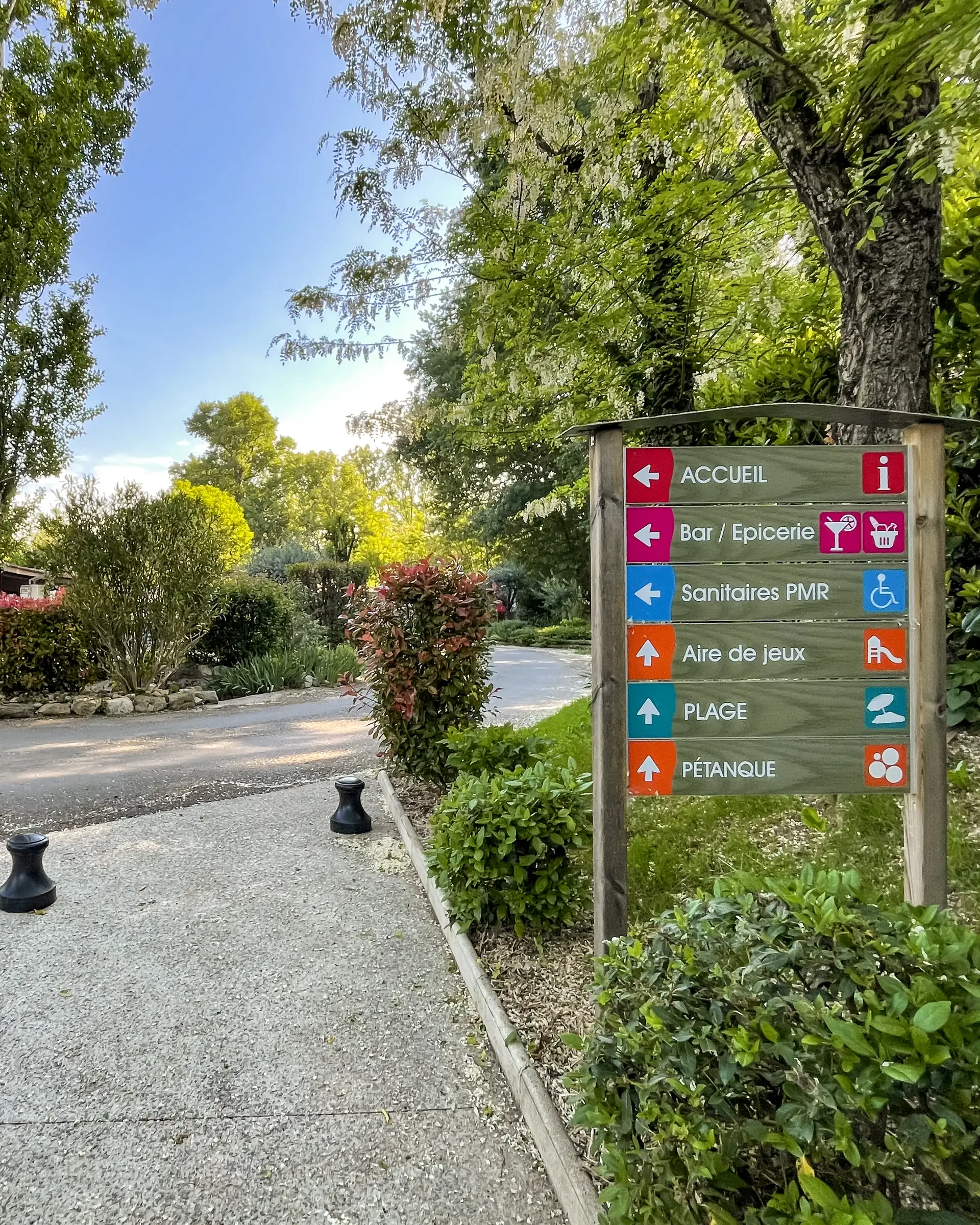 Panneau indiquant la réception, le bar et l'épicerie, les sanitaires, l'aire de jeux, la plage et le terrain de pétanque